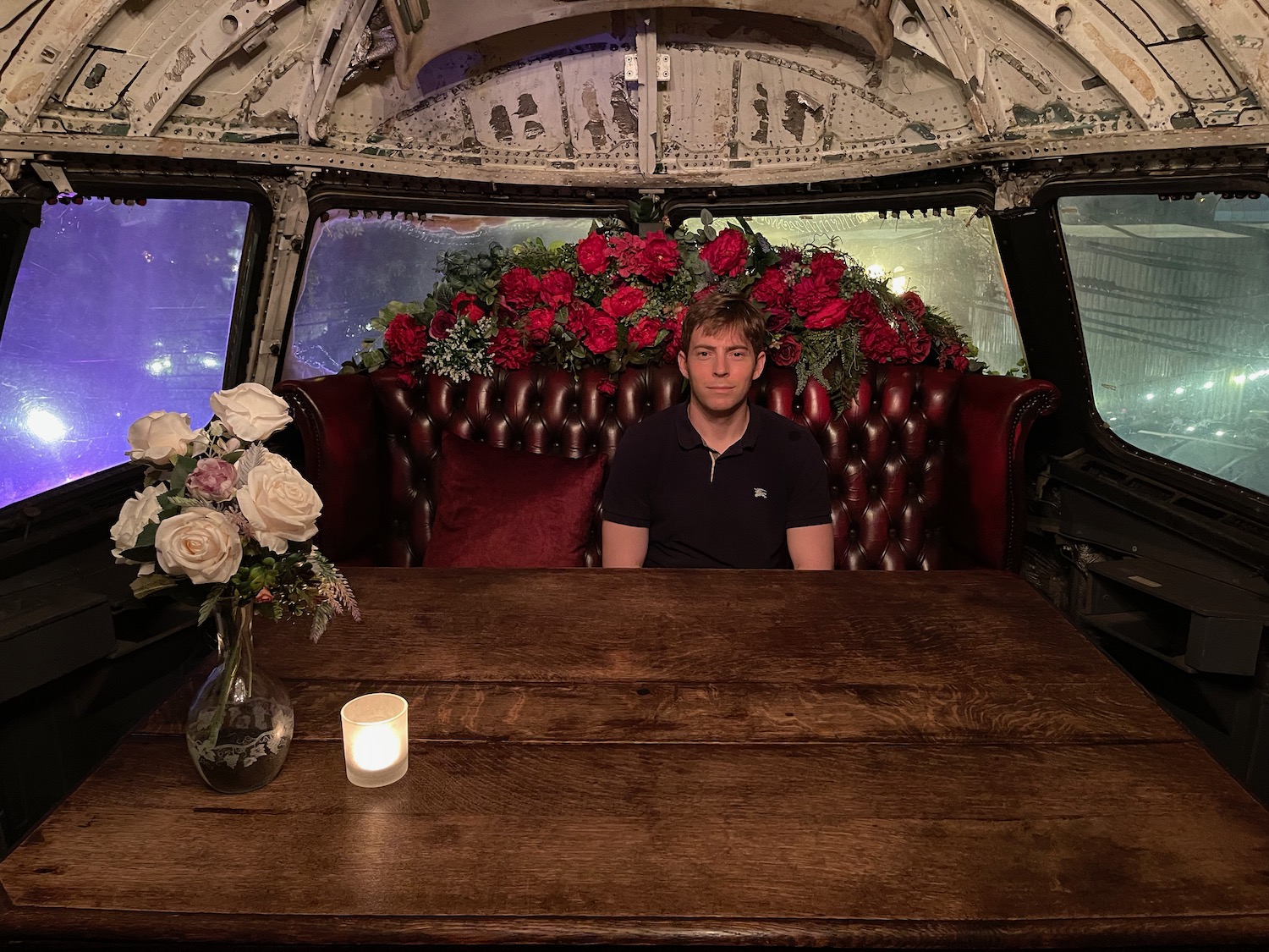a man sitting in a booth with flowers in the background
