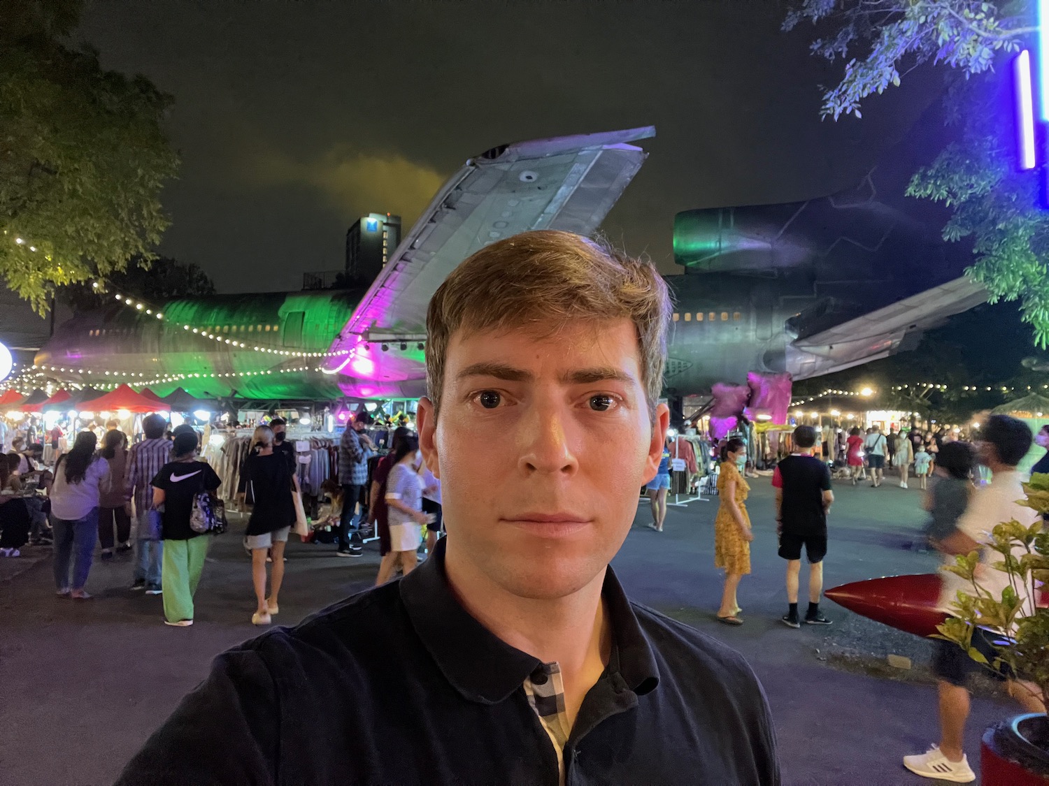 a man taking a selfie in front of an airplane