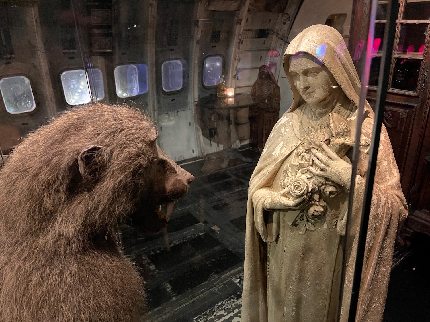 a statue of a bear and a woman in a room with windows