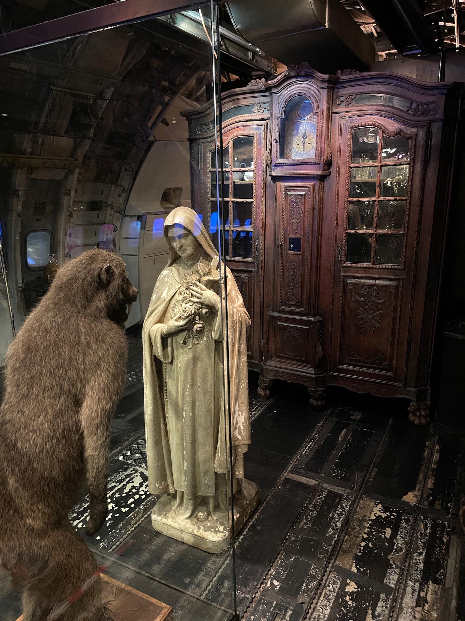 a monkey looking at a statue in a room