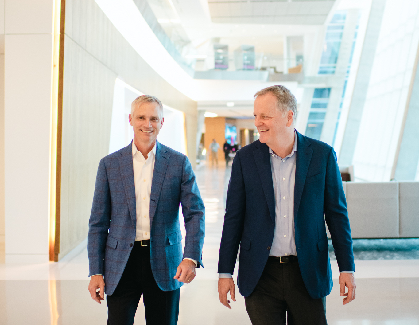 two men in suits walking in a building