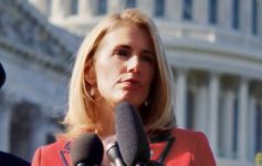 a woman speaking into microphones