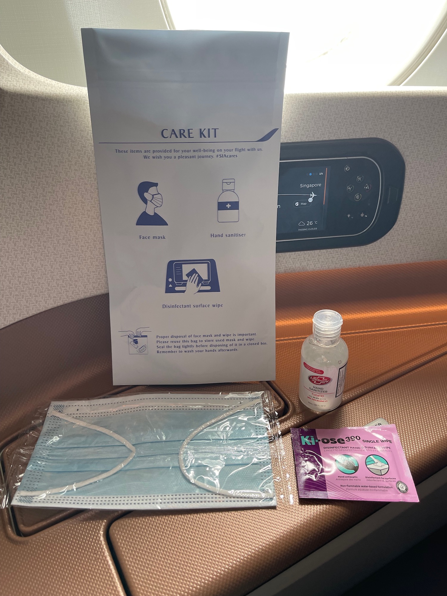 a face mask and hand sanitizer on a seat