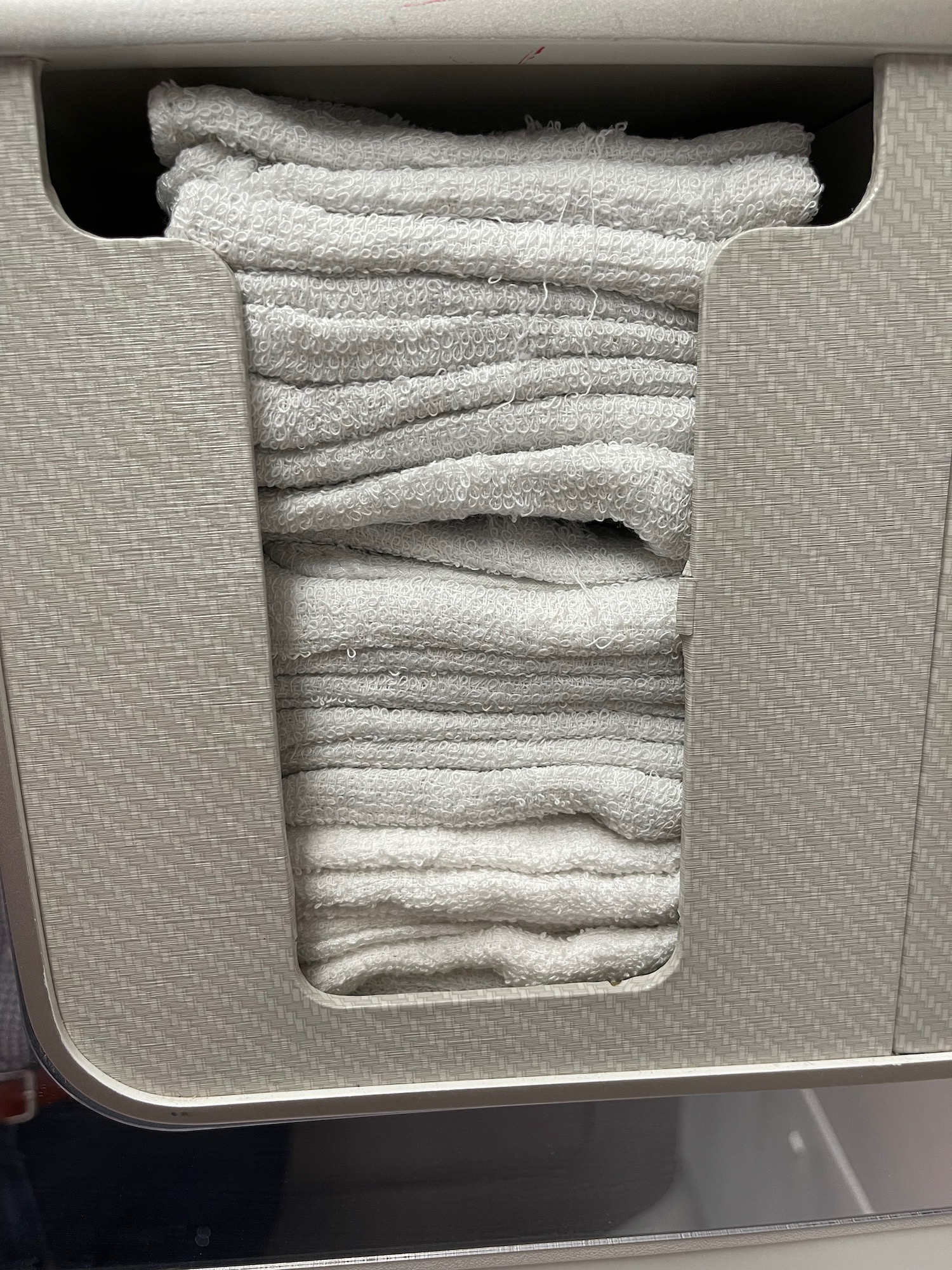 a stack of white towels in a basket