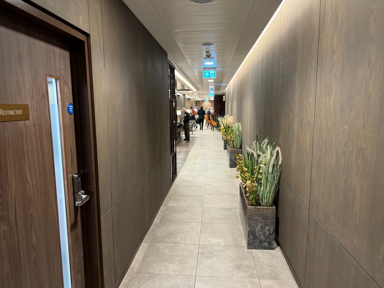 a long hallway with plants in pots