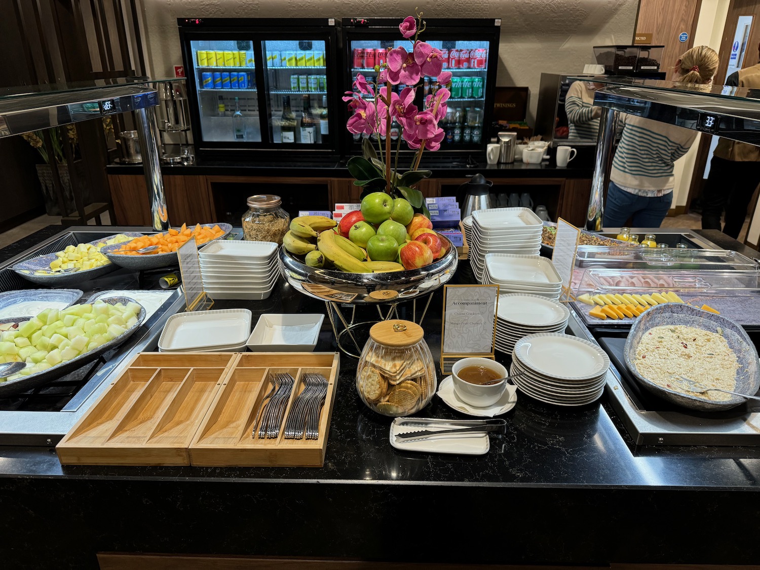 a buffet table with plates and fruit