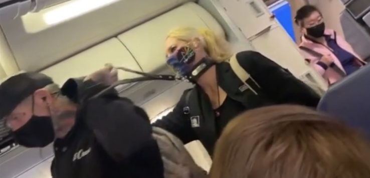 a woman wearing a mask on a plane