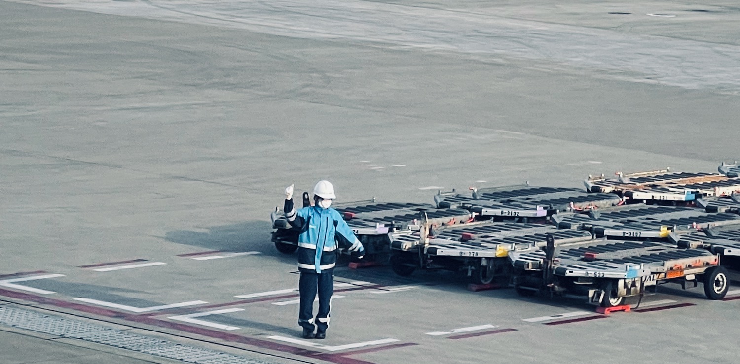 a person in a blue jacket and white helmet standing next to a truck