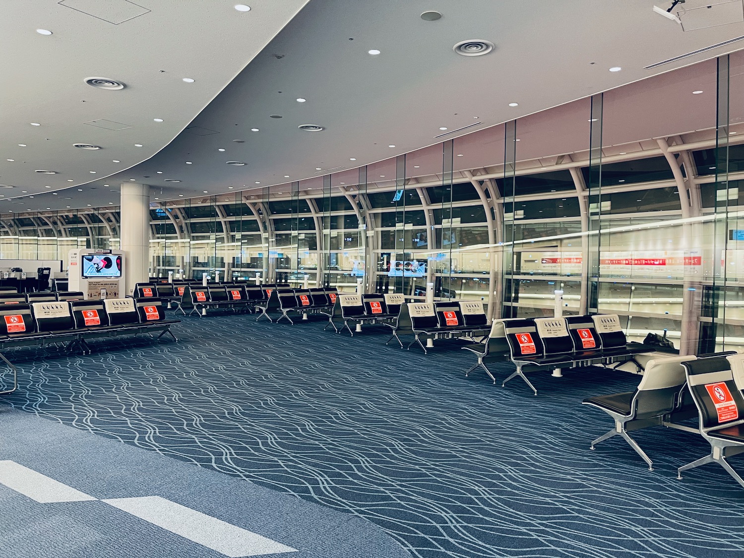 an empty airport terminal with rows of chairs