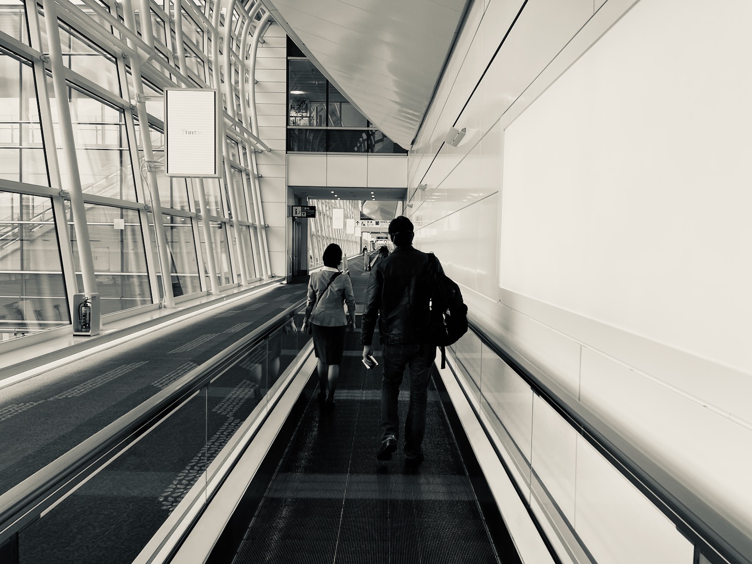 a man and woman walking down a walkway