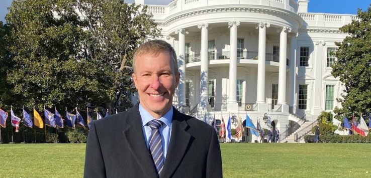 a man standing in front of a white house