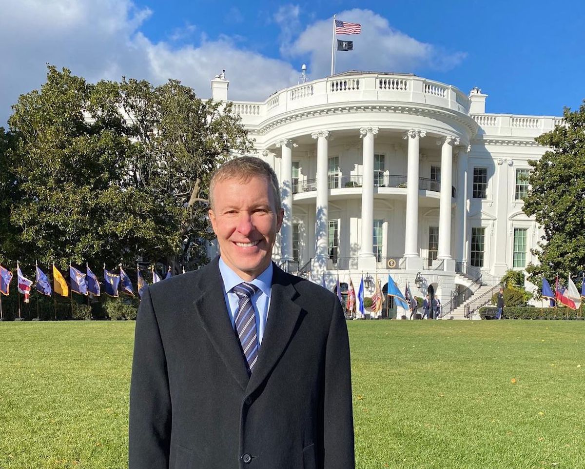 a man standing in front of a white house