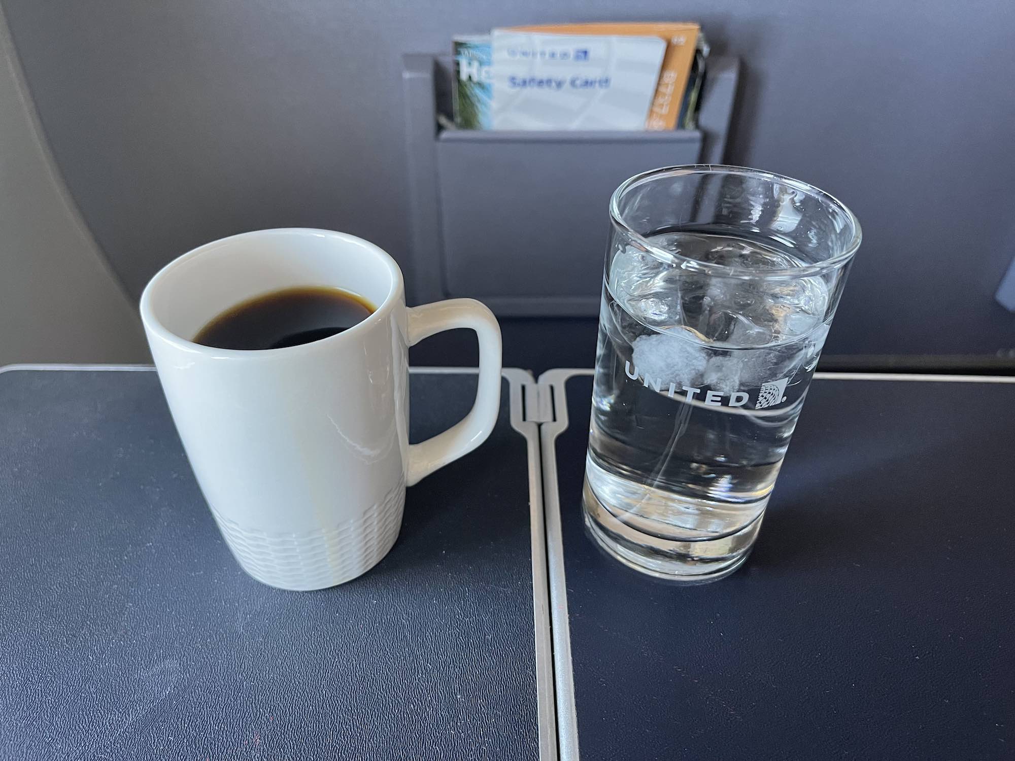 a cup of coffee and a glass of water on a table