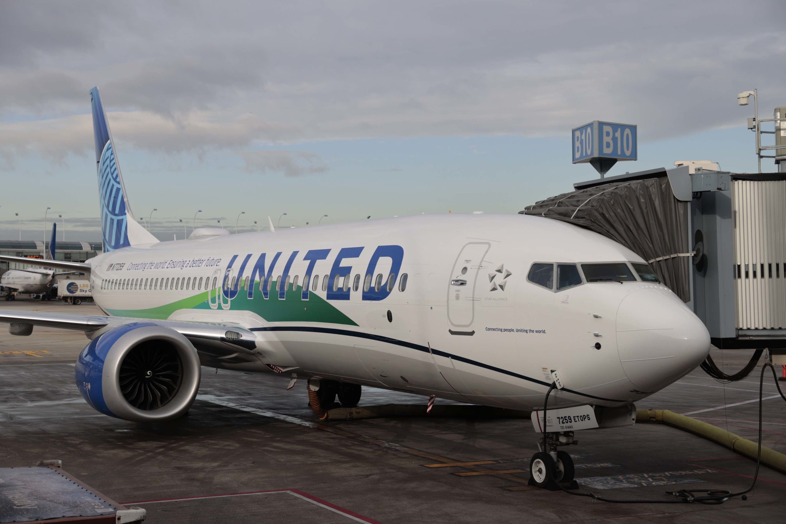 a white airplane with blue and green text on it