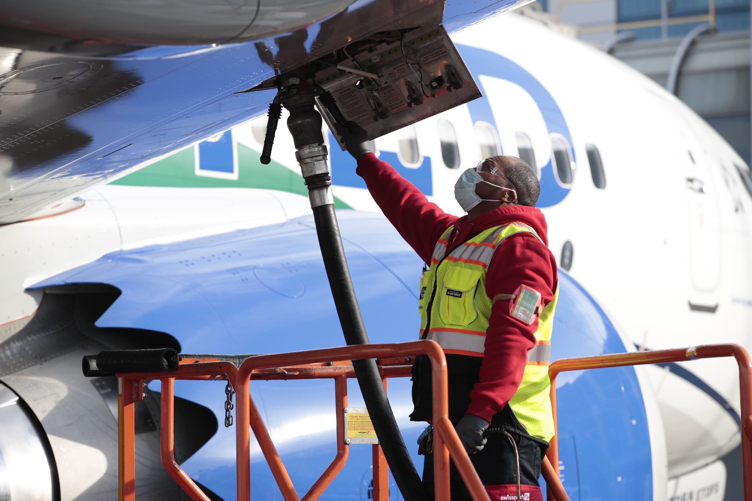 a man in a safety vest and mask working on an airplane