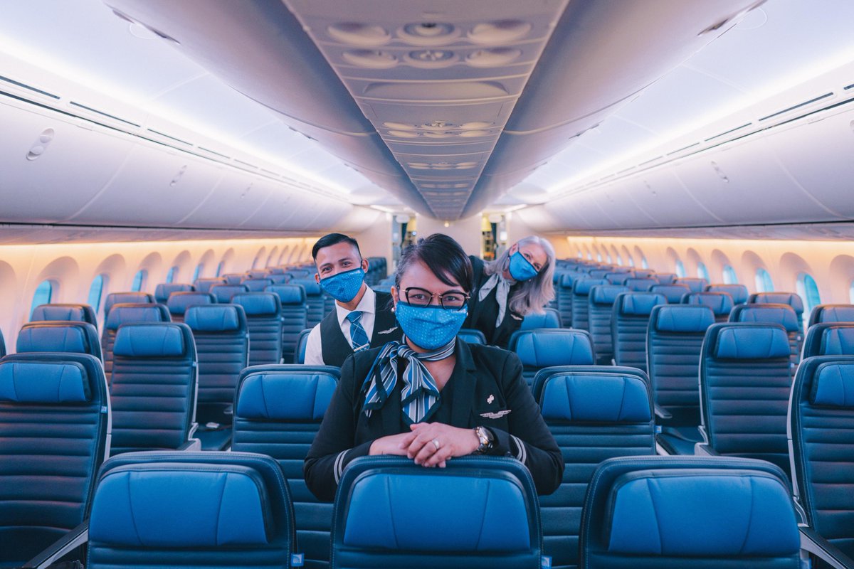 a group of people wearing face masks in an airplane