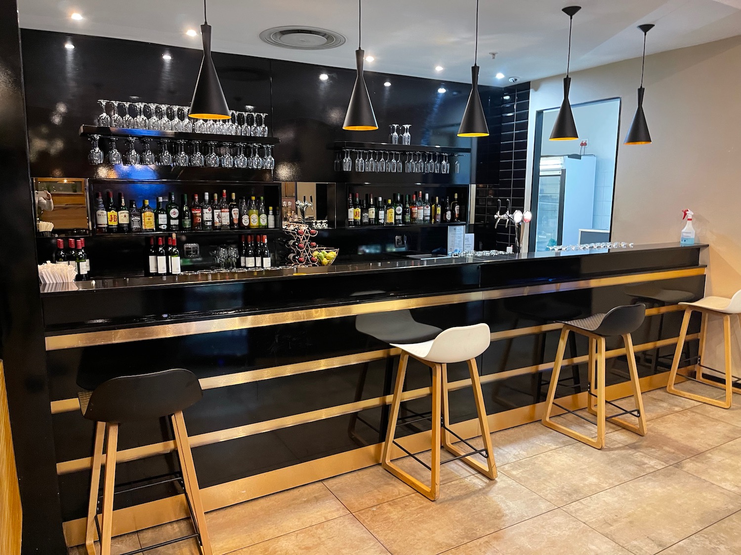 a bar with black counter and black stools