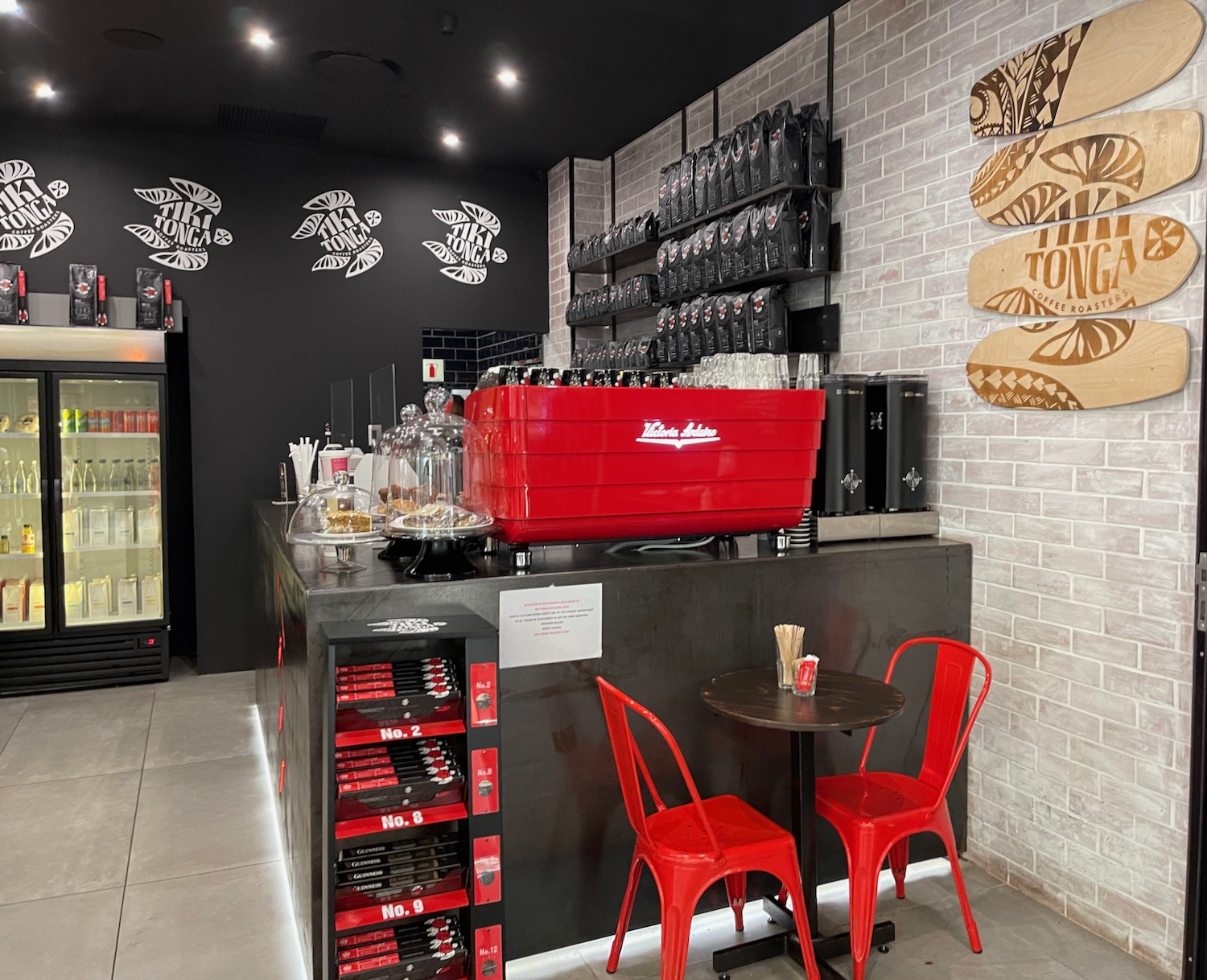 a counter with red chairs and a red cooler