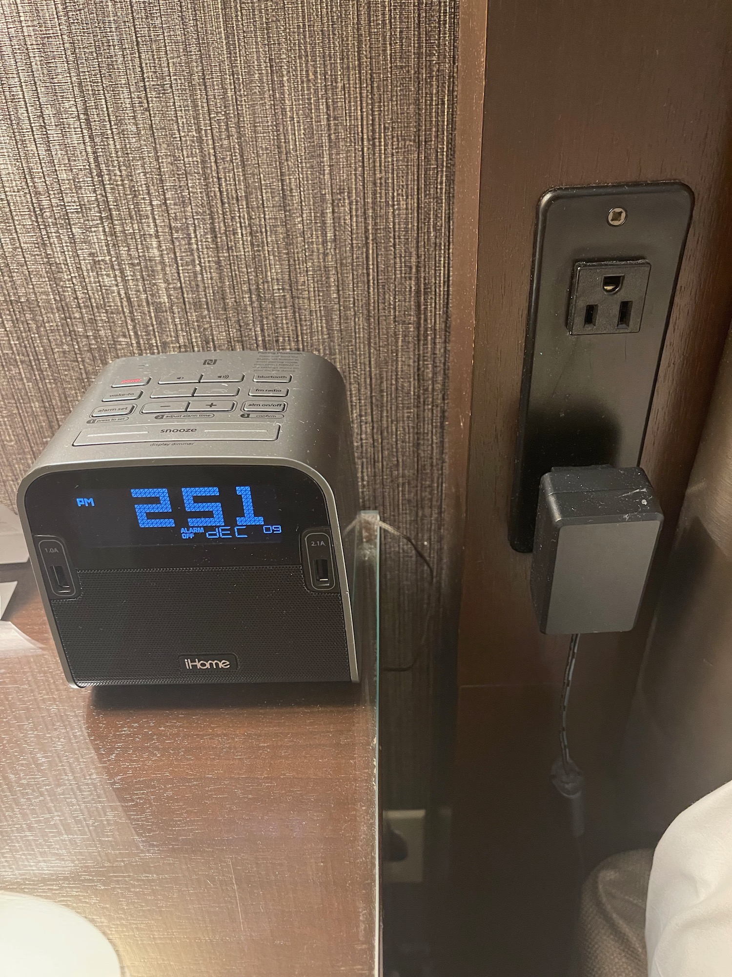 a black alarm clock next to a wall outlet