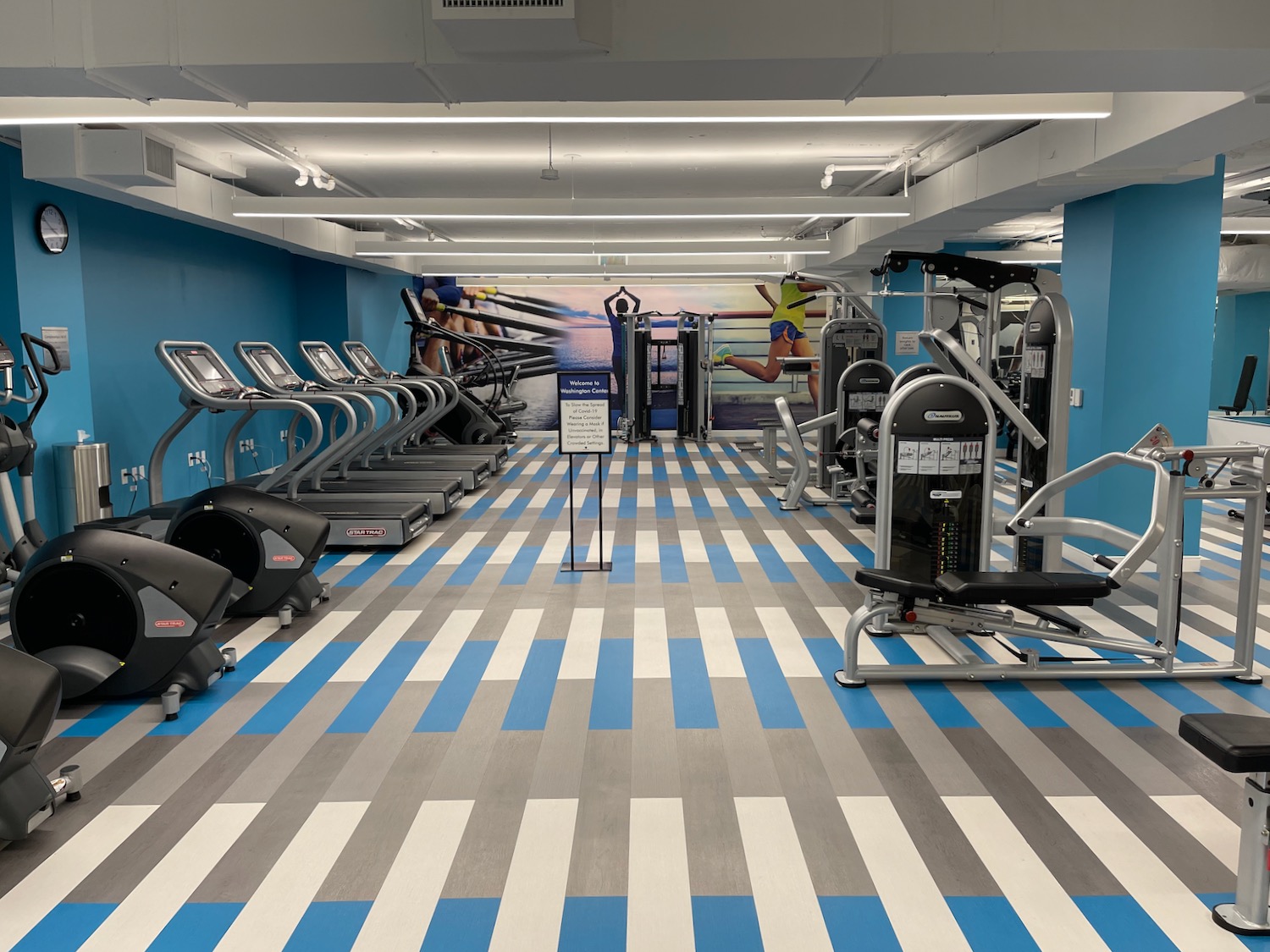 a gym with several treadmills