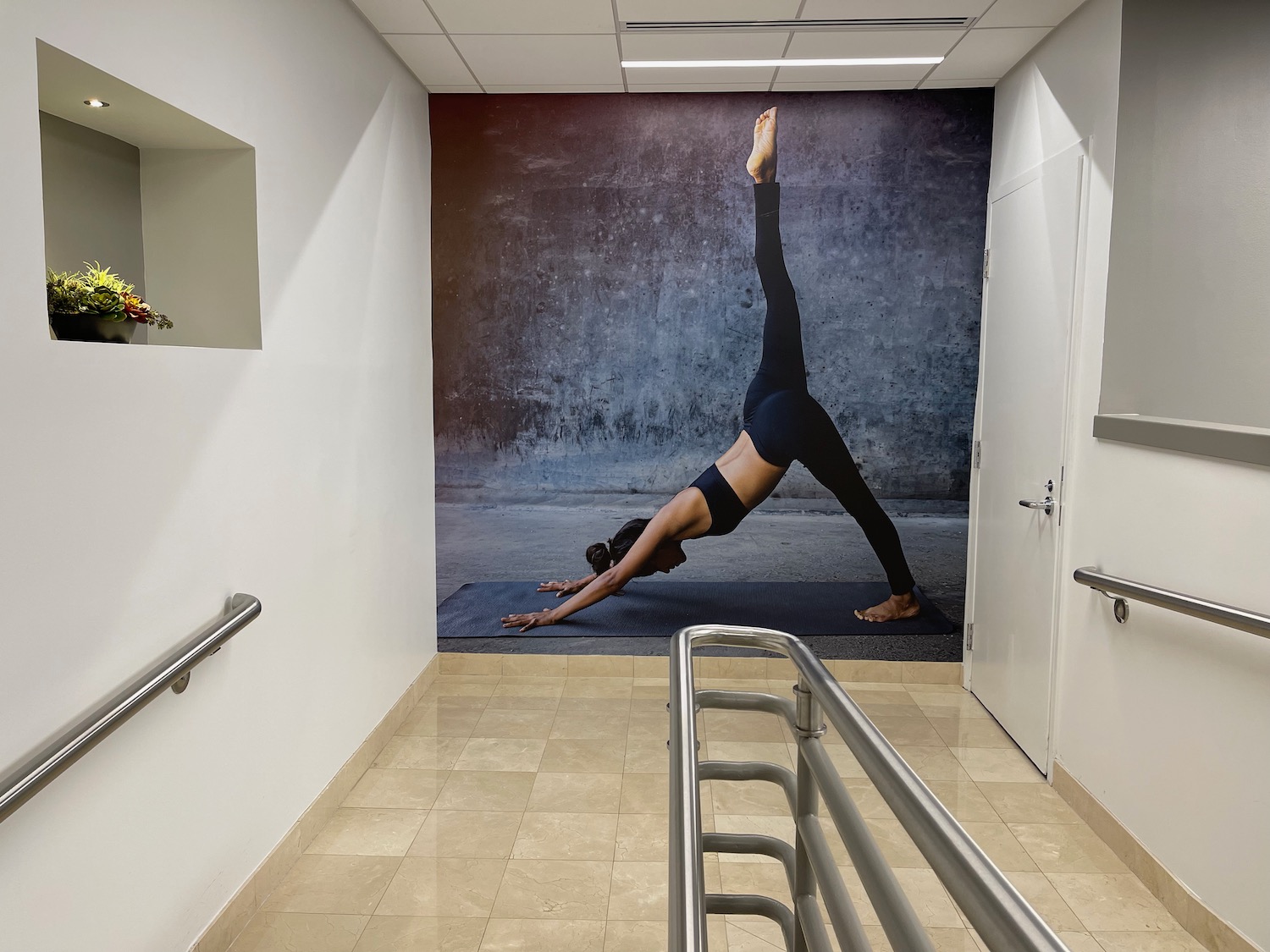 a woman doing yoga on a mat in a hallway