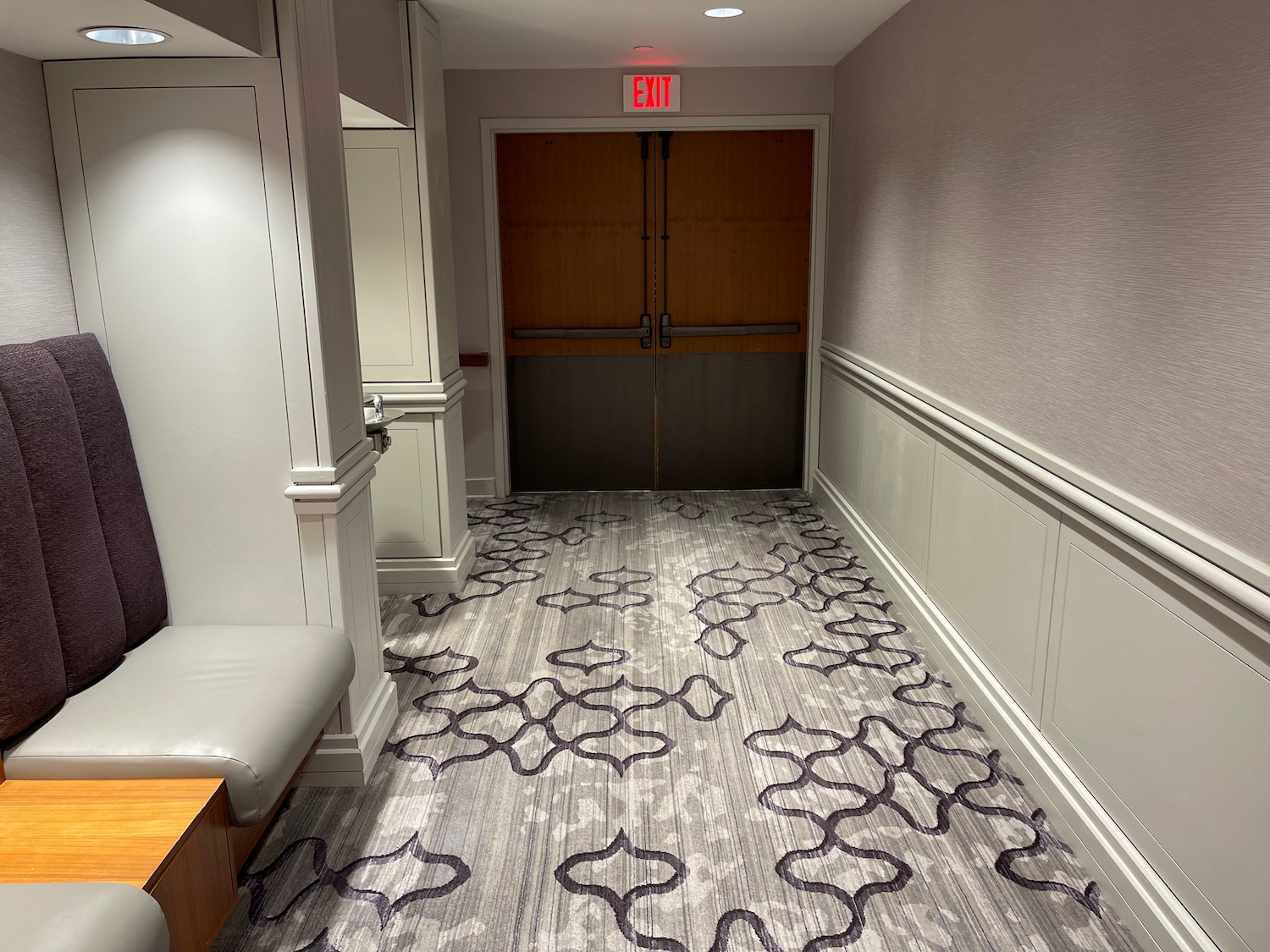 a hallway with a door and a carpet