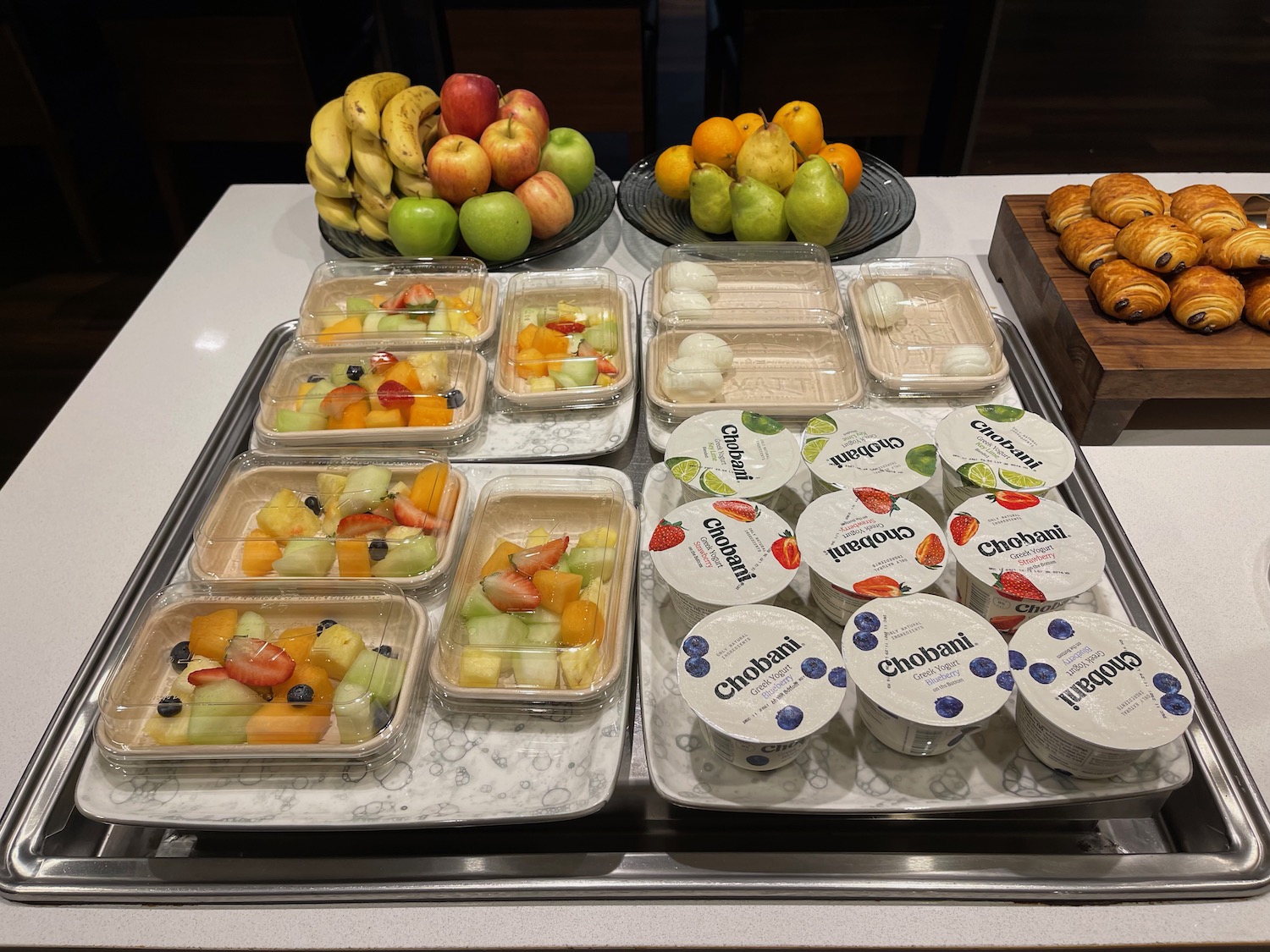 a trays of fruit and yogurt on a table