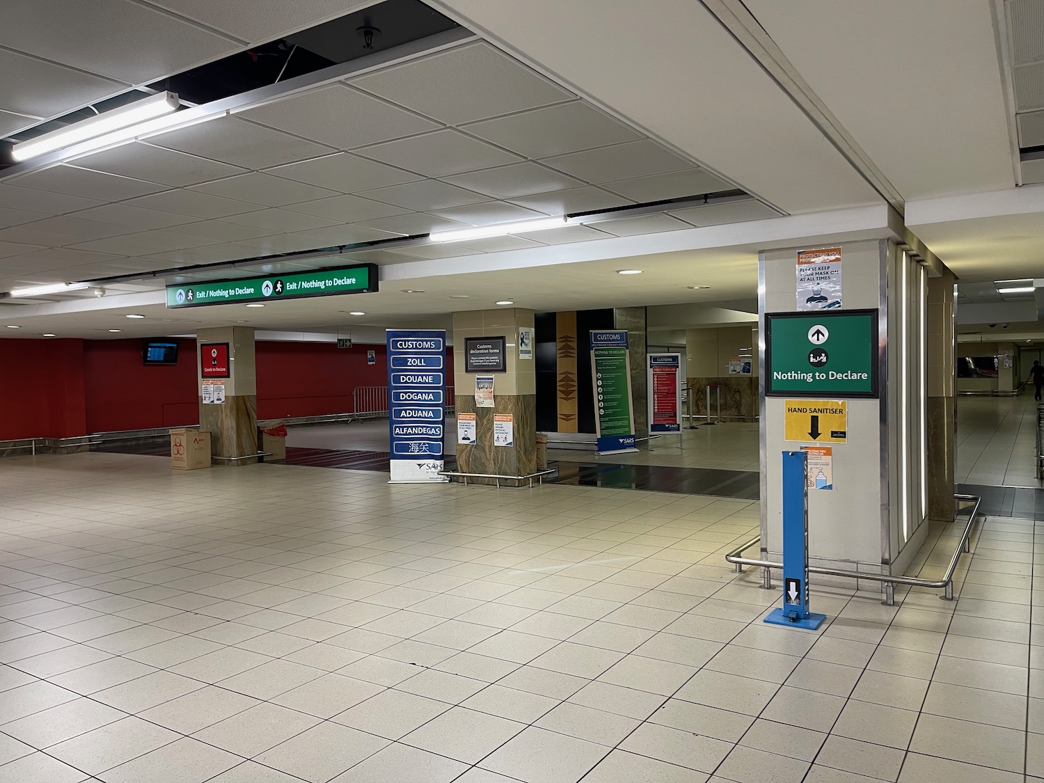 a large white tiled floor with signs and a green sign