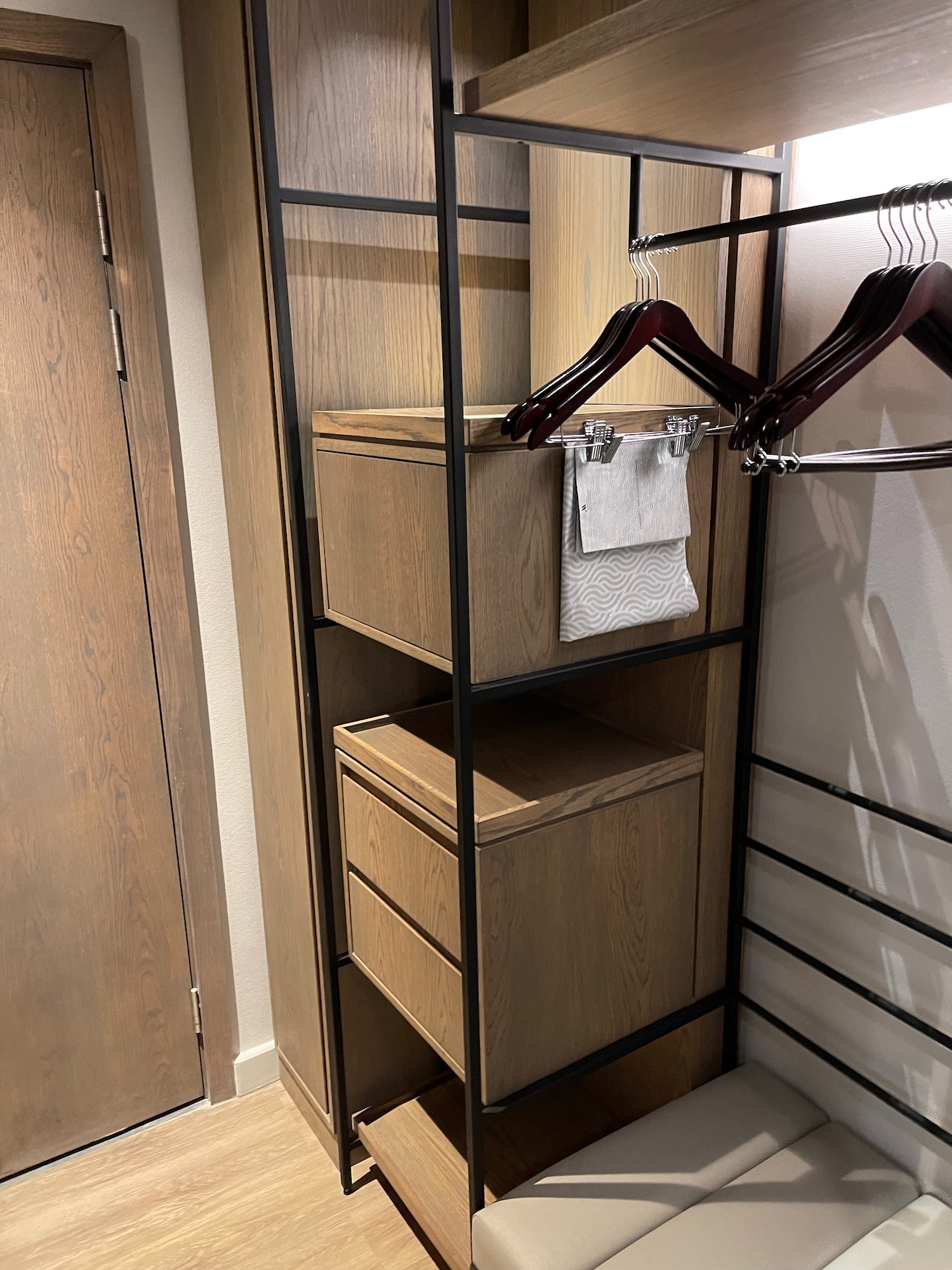 a closet with a shelf and swingers