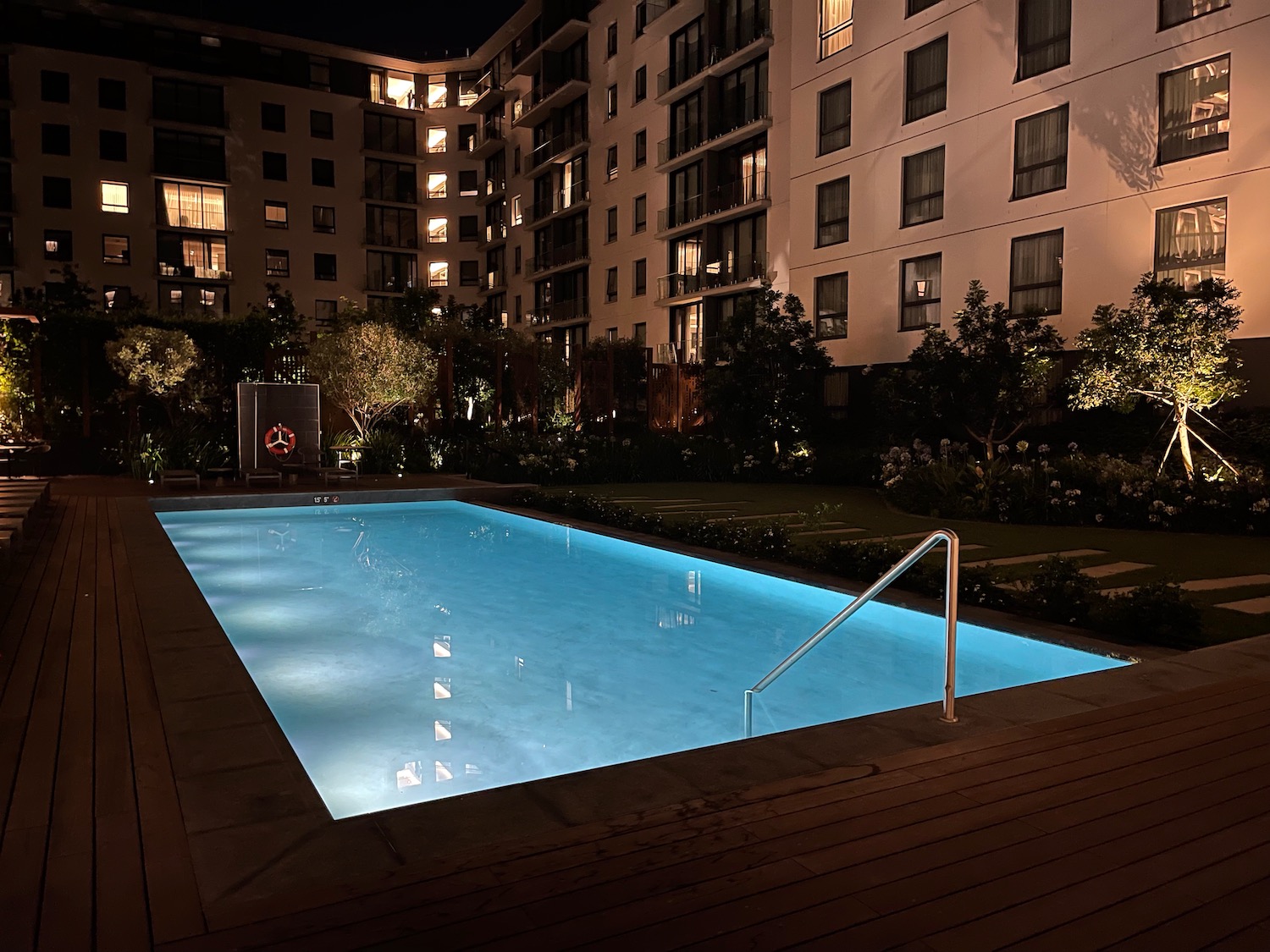 a pool with a railing in front of a building