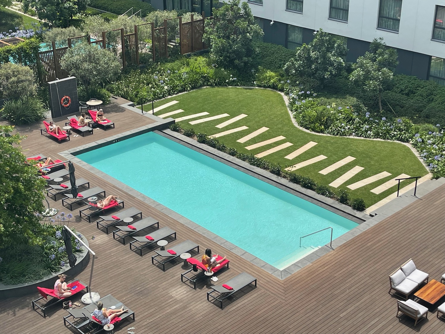 a pool with lounge chairs and a building