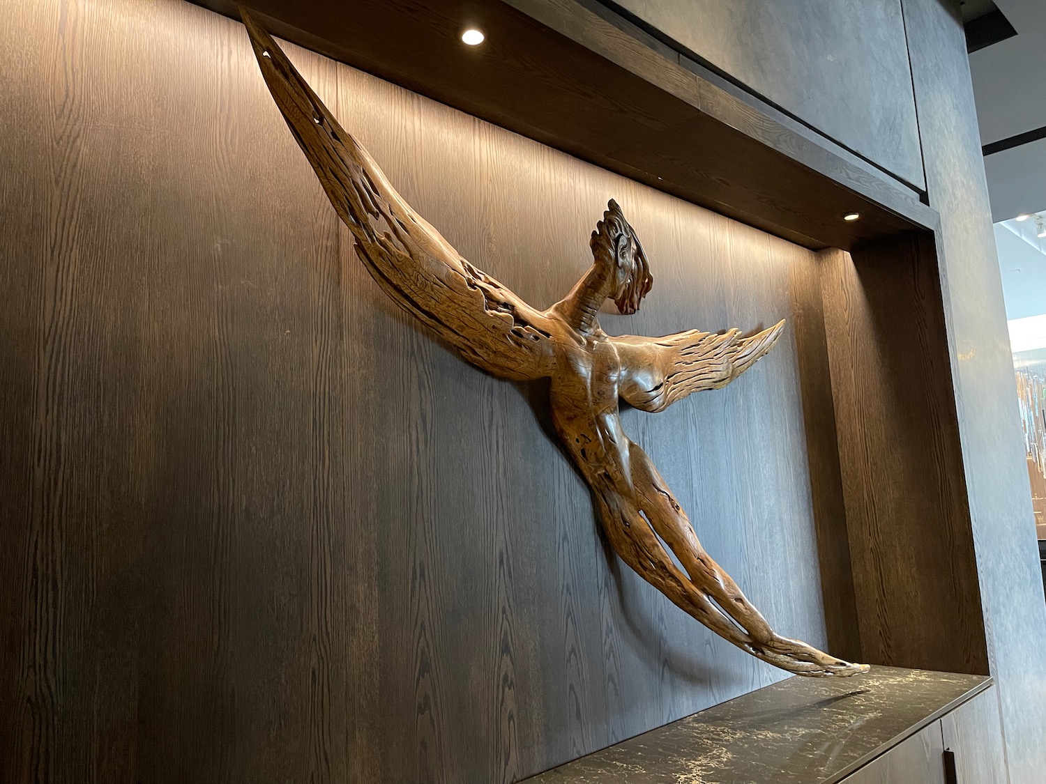 a wood sculpture of a bird on a wall