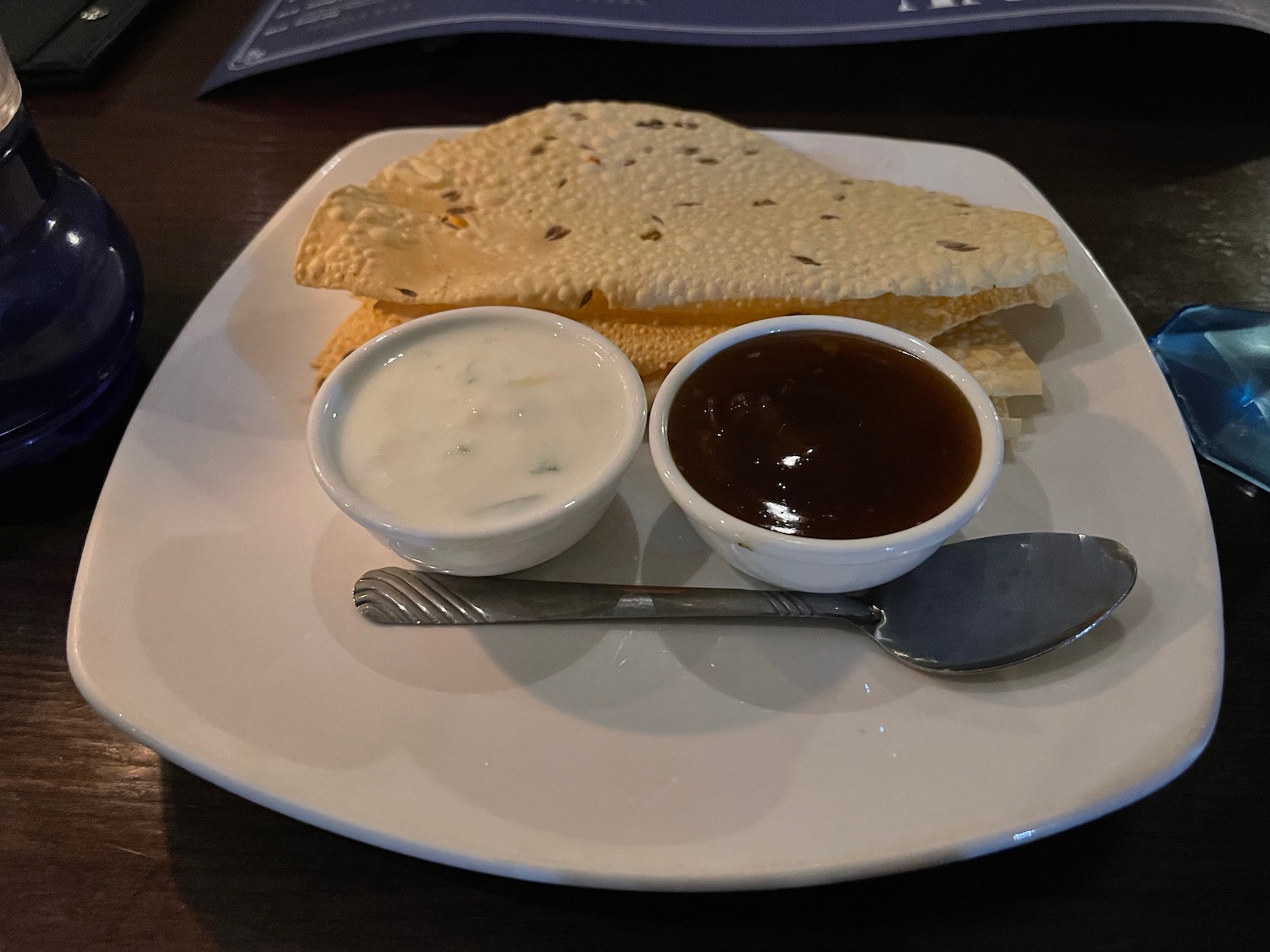 a plate of food with sauces and a spoon