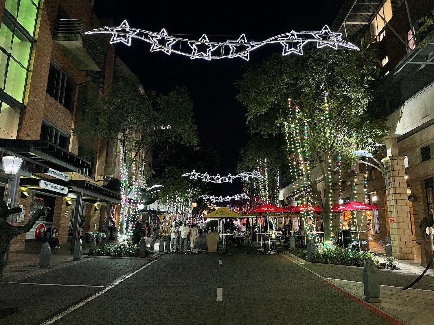 a street with lights and people walking around