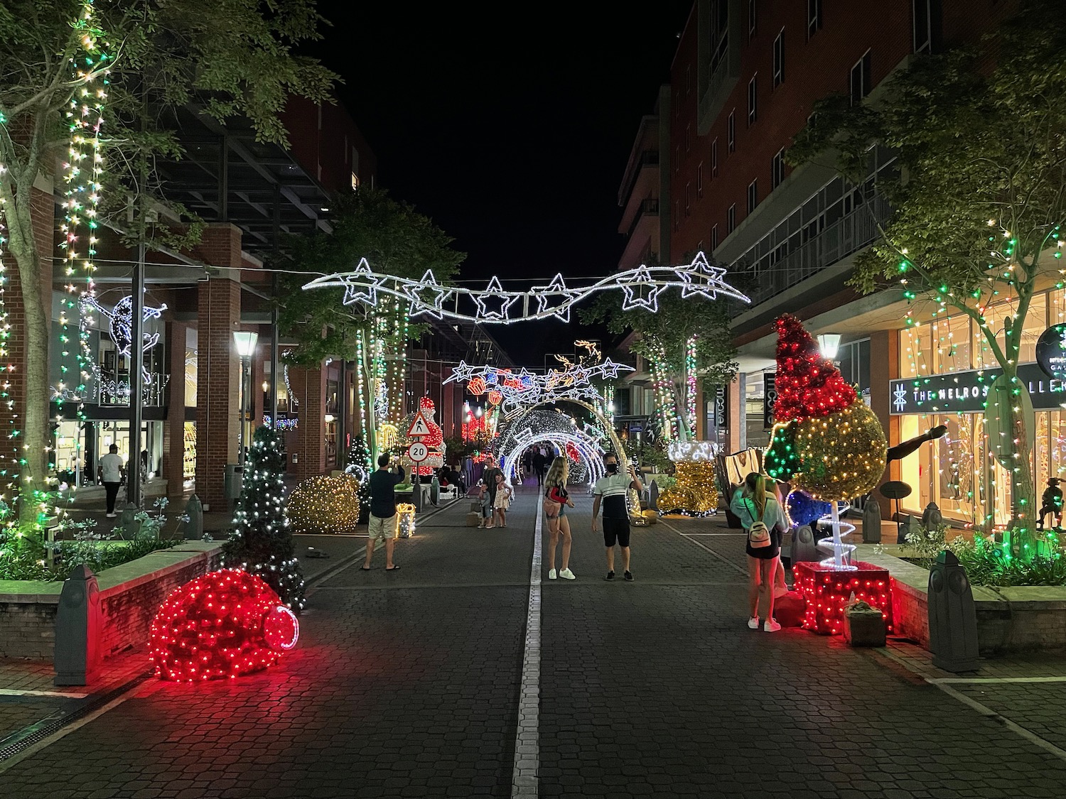 a street with lights and people walking on it