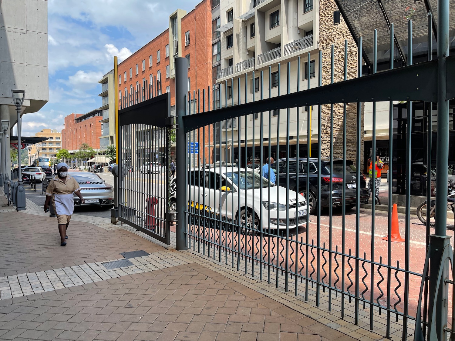 a person walking on a sidewalk with a gate