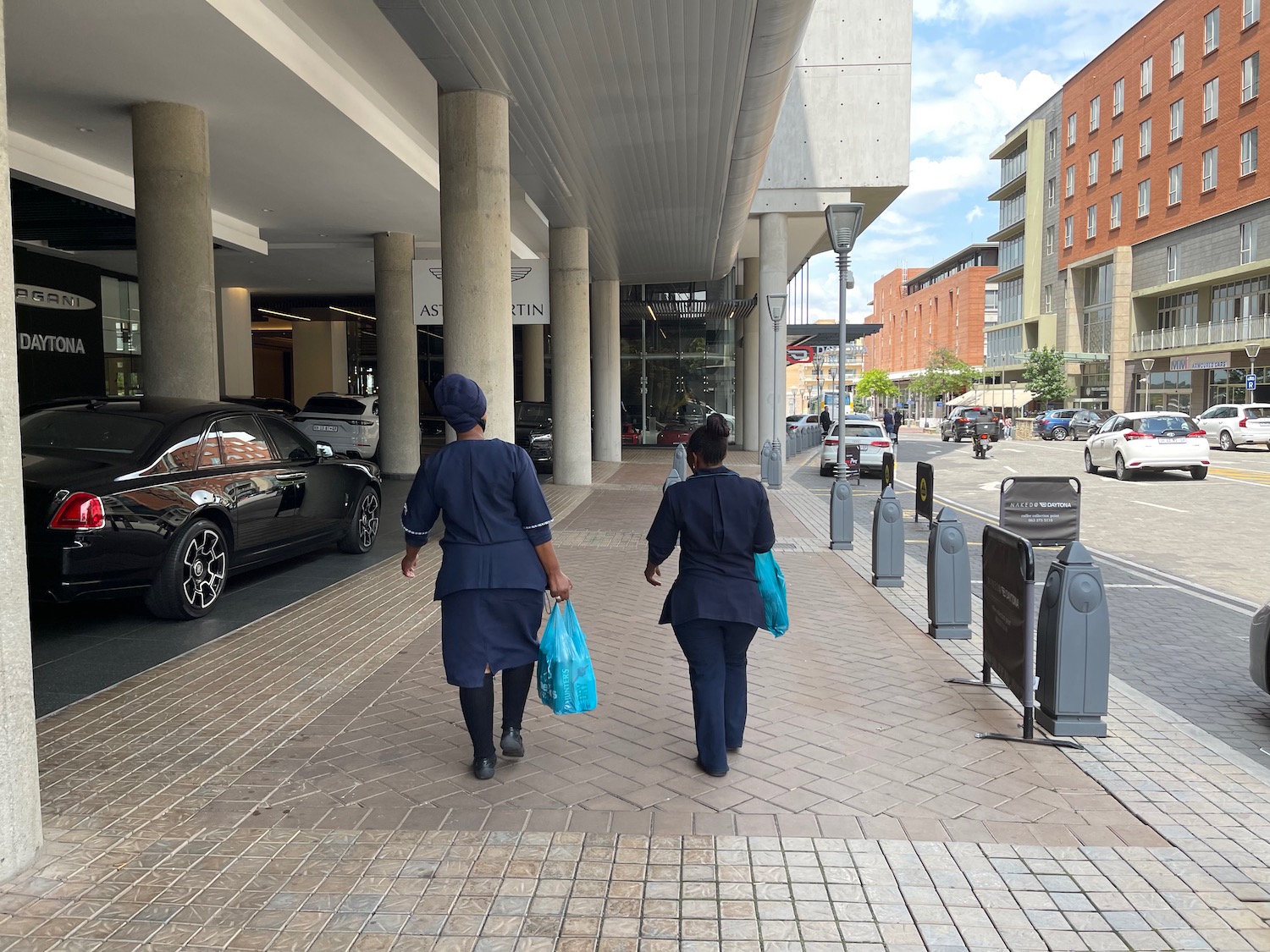 two women in blue uniforms walking down a sidewalk