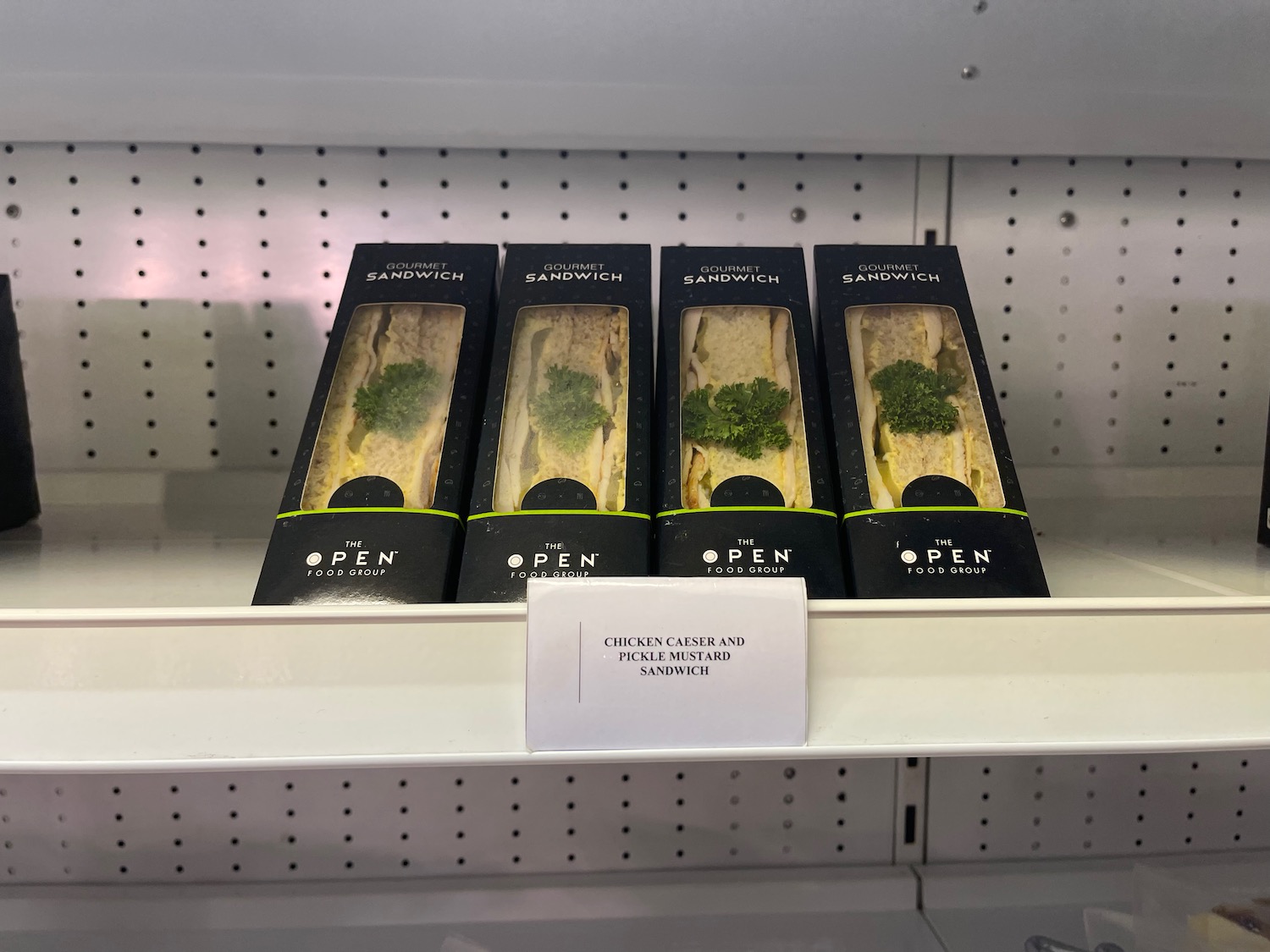 a group of sandwiches in boxes on a shelf