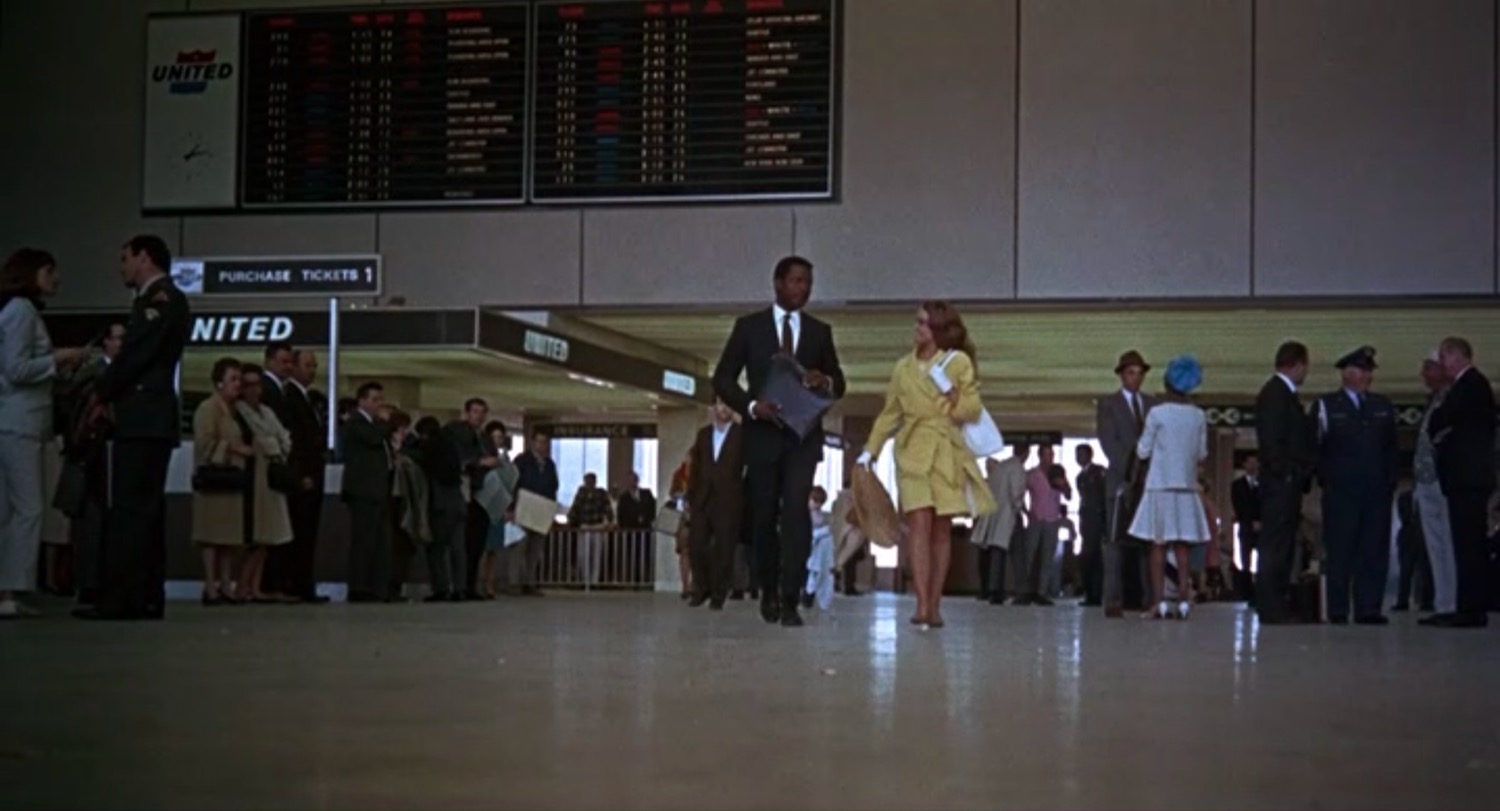 a man and woman walking in a terminal