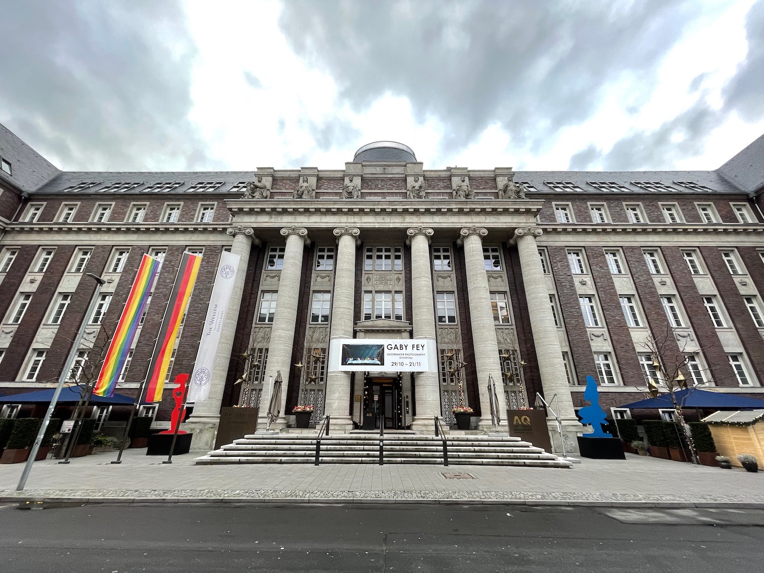 a large building with columns and flags