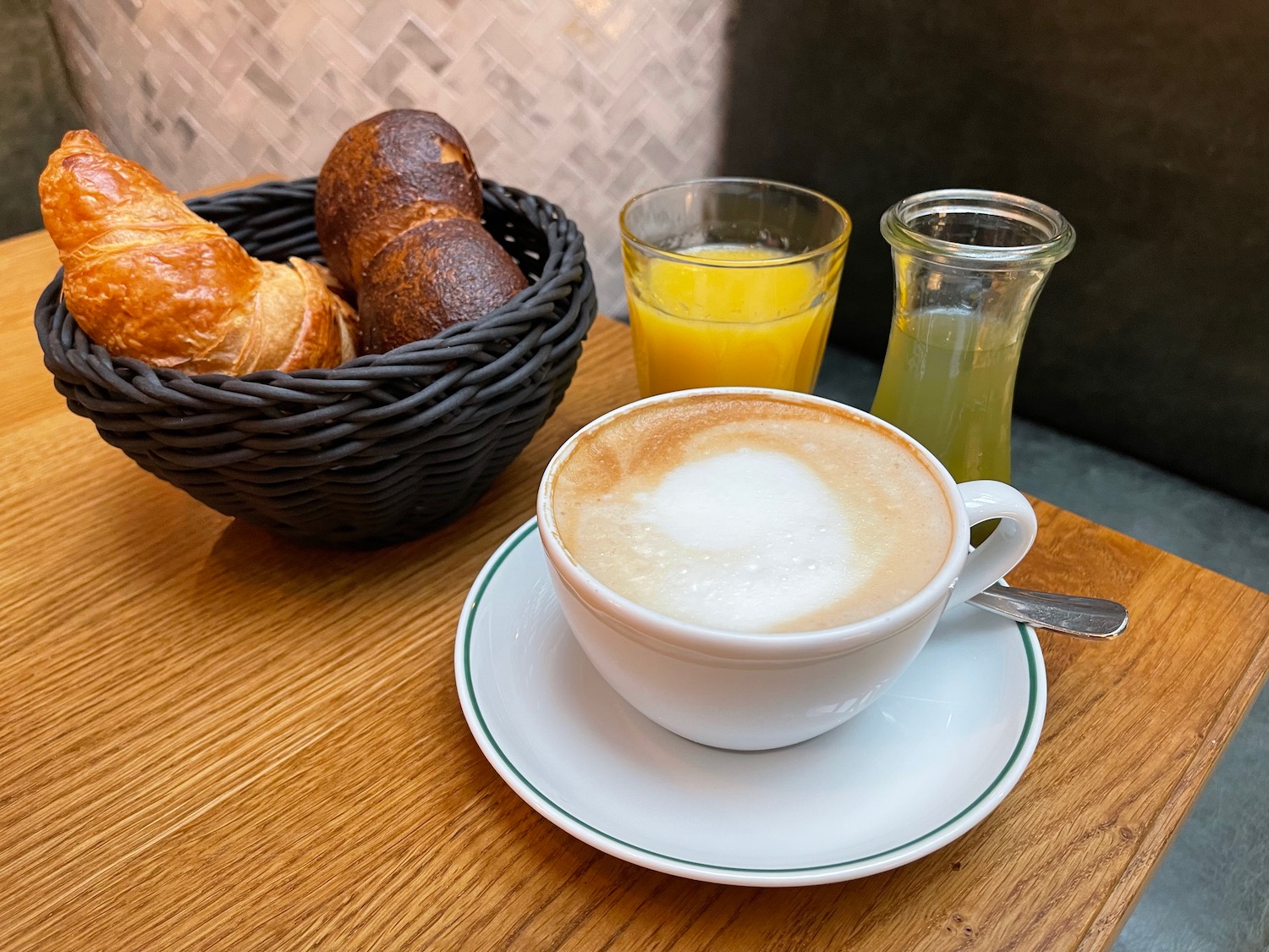 a cup of coffee and a basket of croissants