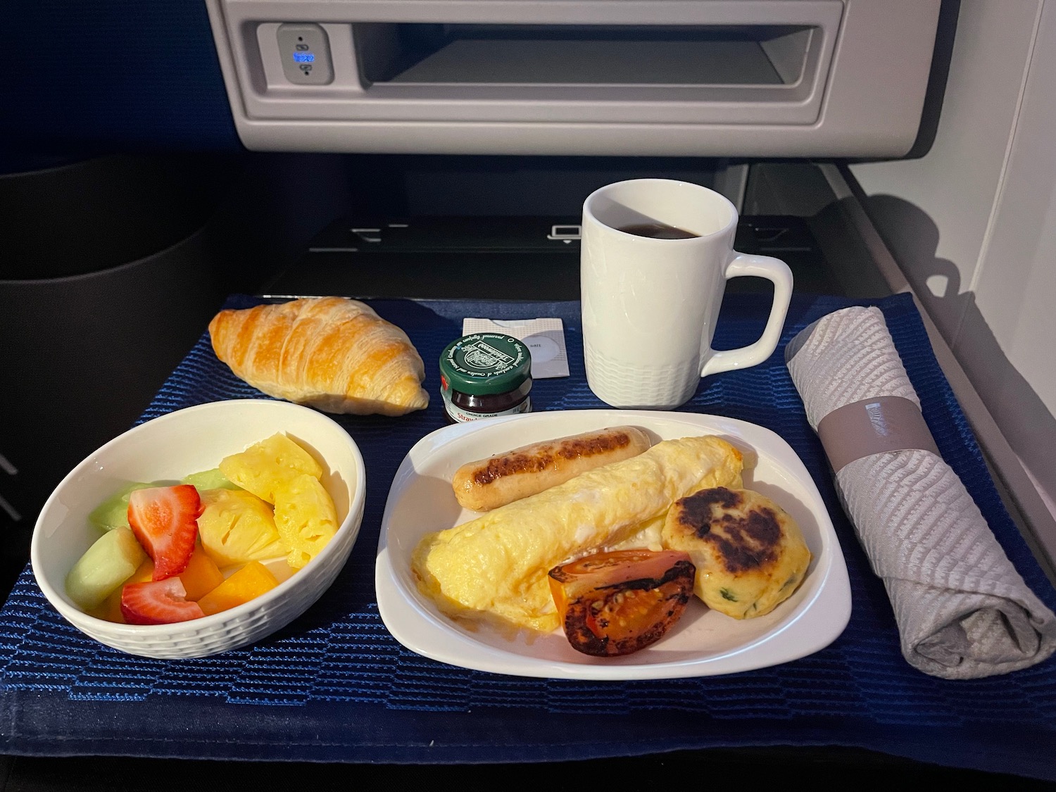 a plate of food and a cup of coffee on a tray