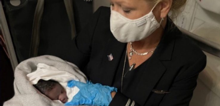 a woman wearing a mask and holding a baby