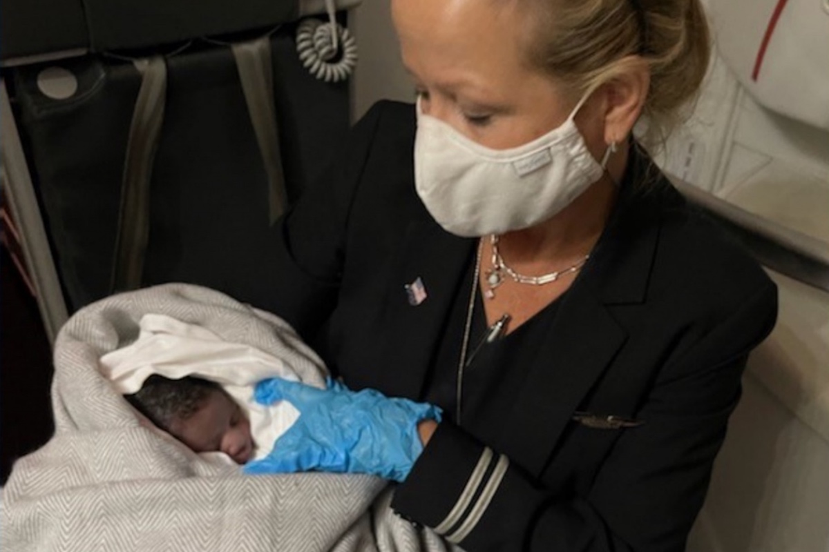 a woman wearing a mask and holding a baby