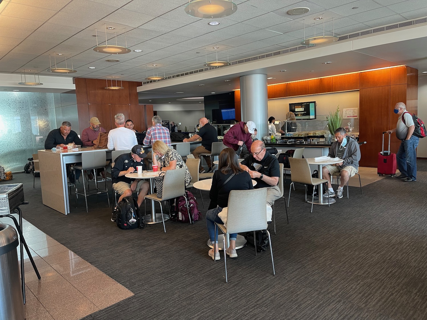 a group of people sitting at tables in a room with a large wall