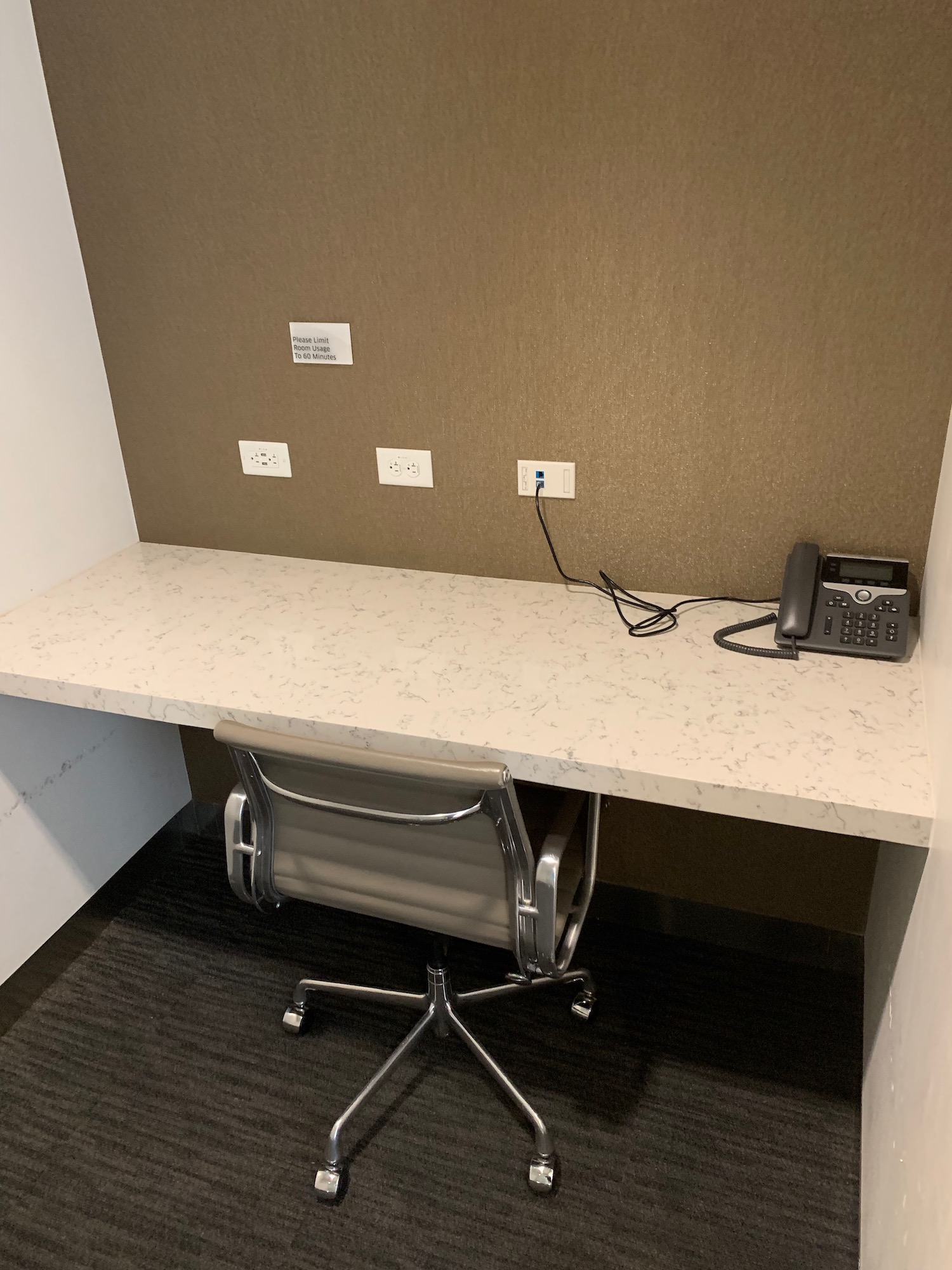 a desk with a chair and a telephone on it