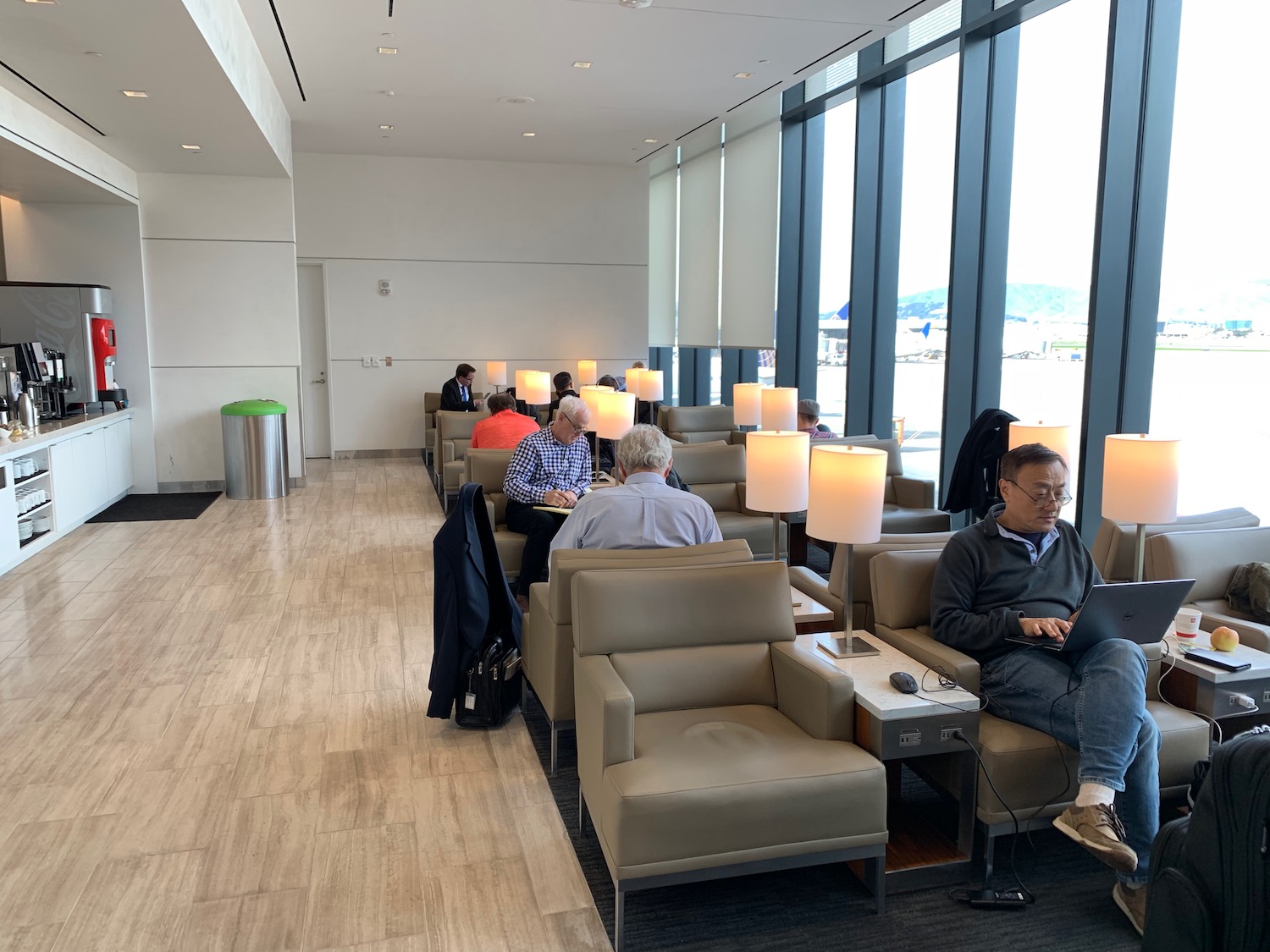 a group of people sitting in chairs in a room with windows