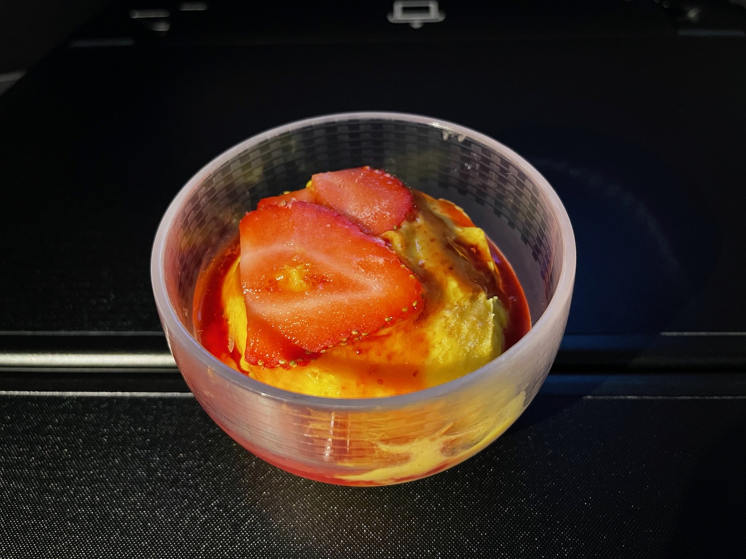 a bowl of ice cream with a strawberry on top