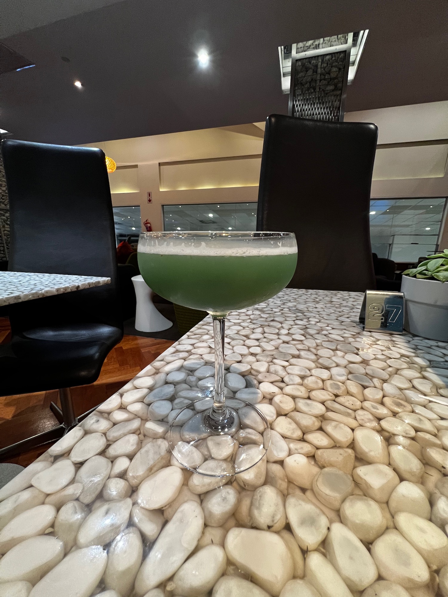 a glass of green liquid on a table