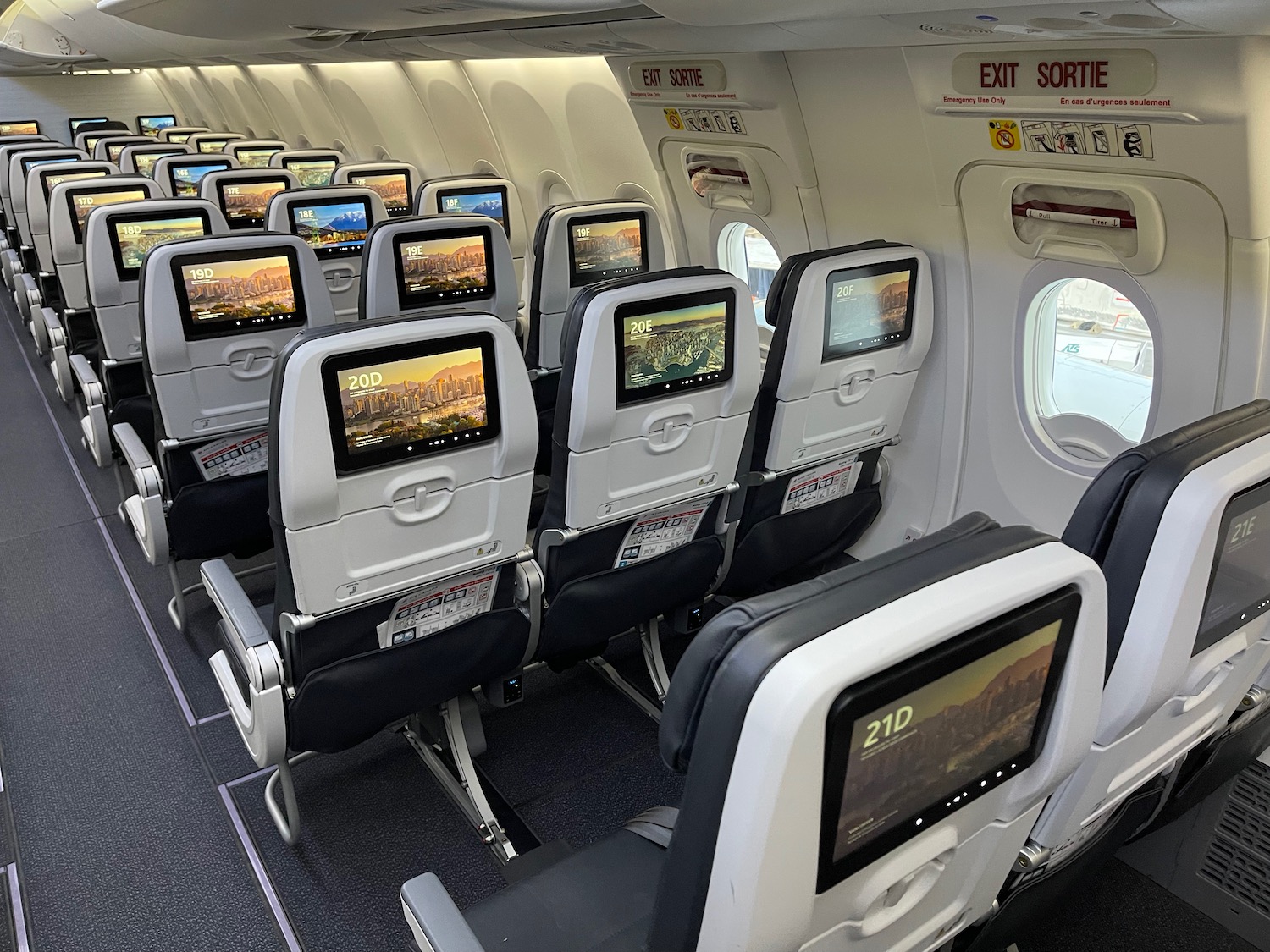 a row of seats with monitors on the side